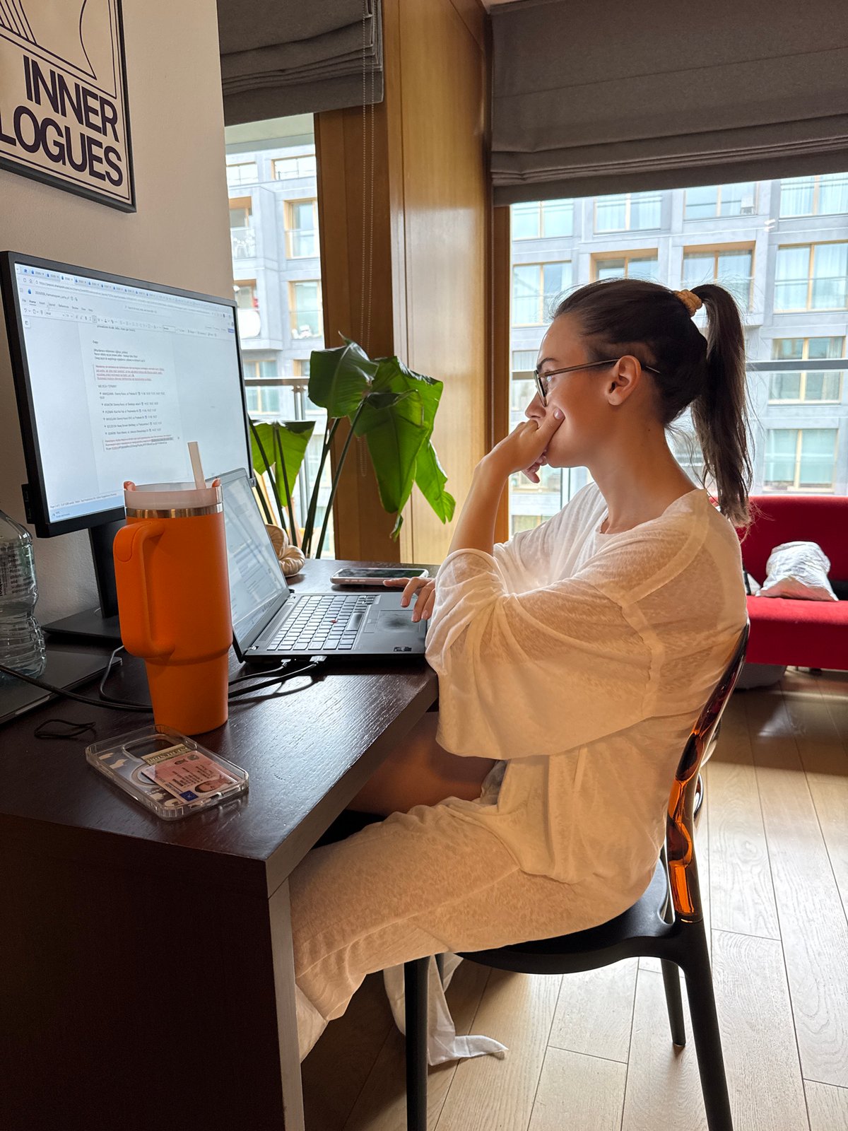 Woman observed in thoughtful pose at desk workspace