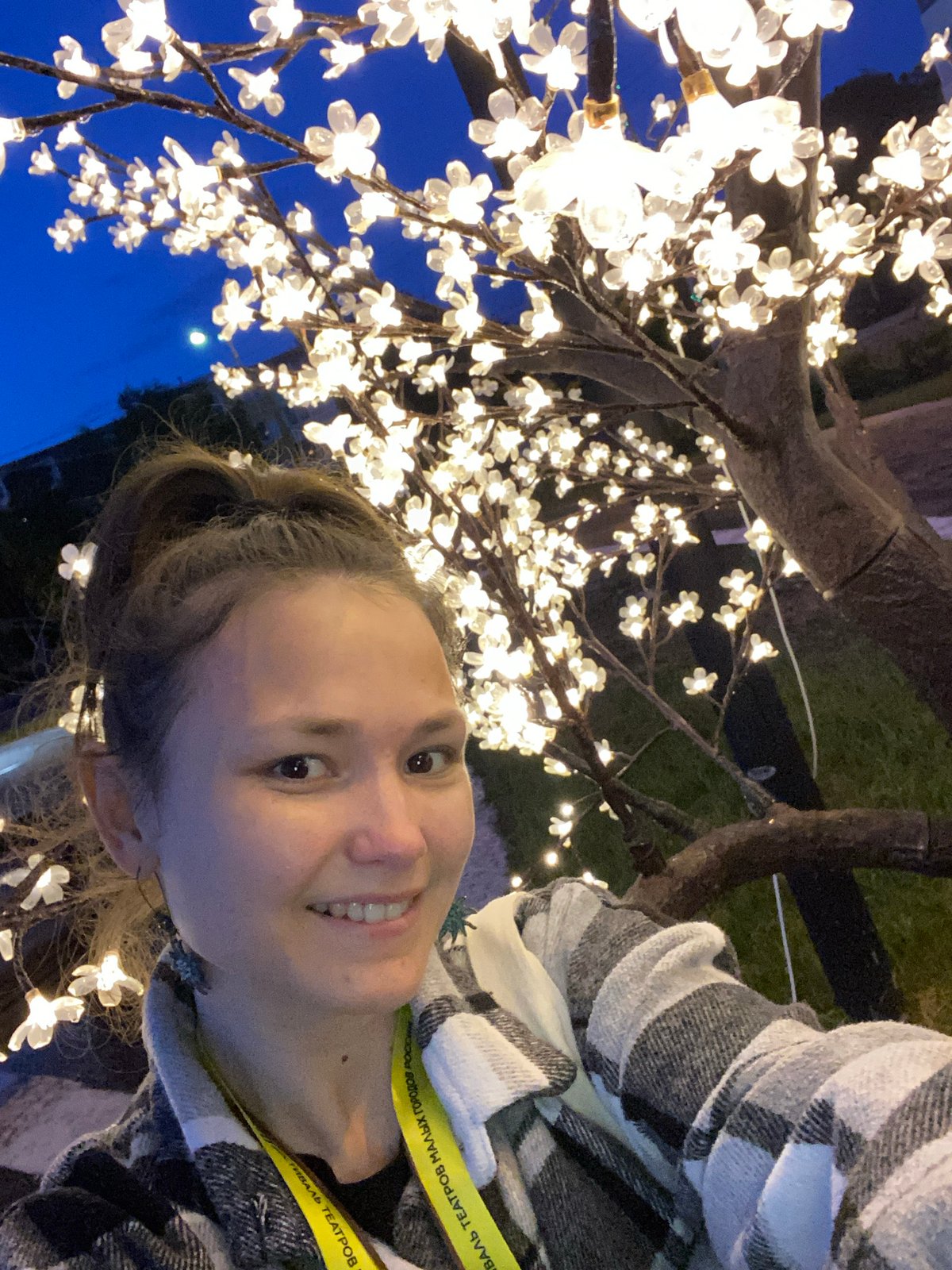 Woman poses by illuminated tree in Peresvet, Russia