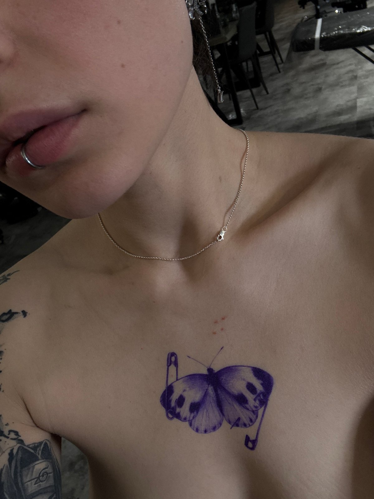 Person displays butterfly tattoo with safety pins in Moscow
