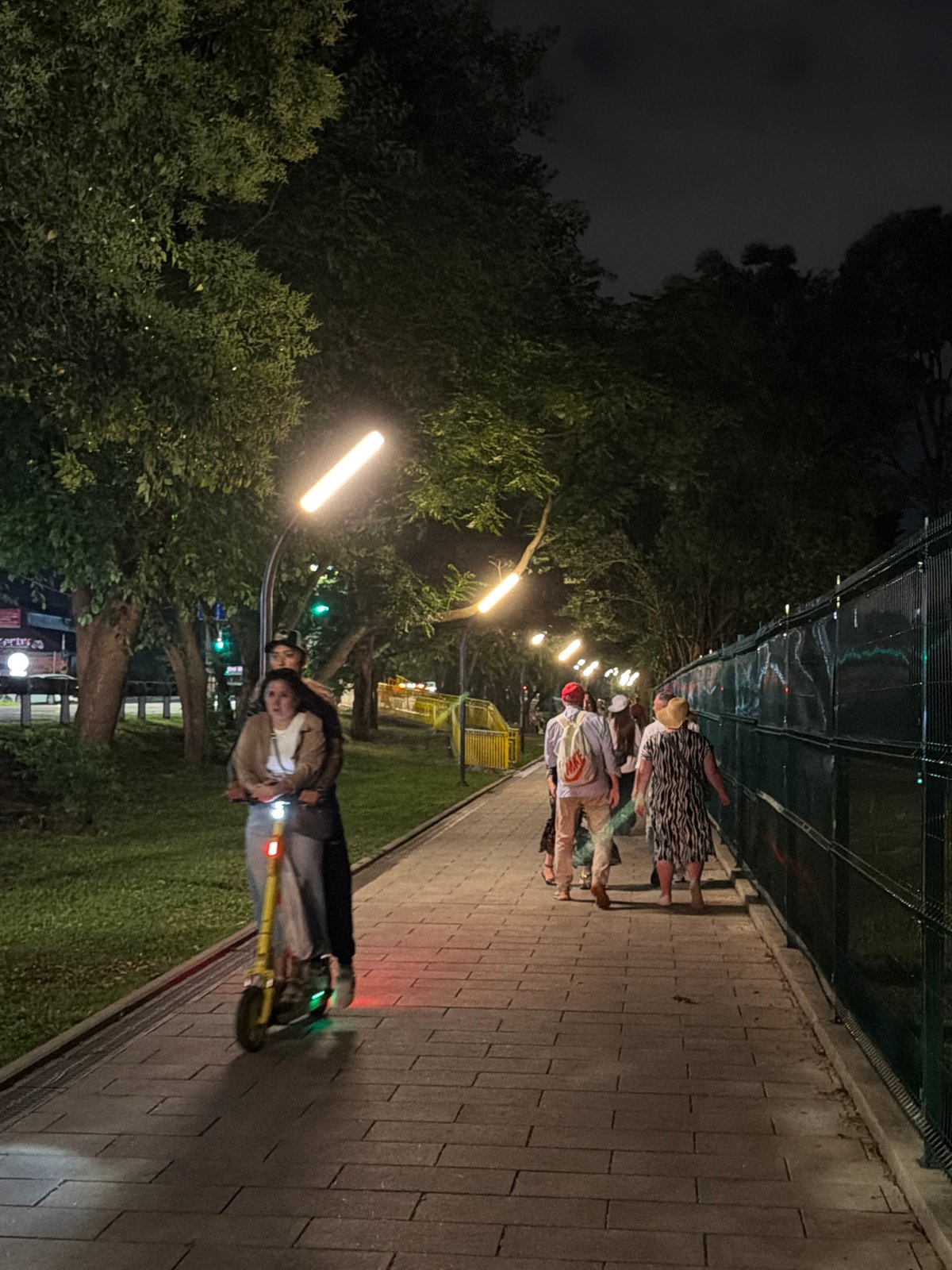 Evening foot traffic along a lit pedestrian path in Sirius