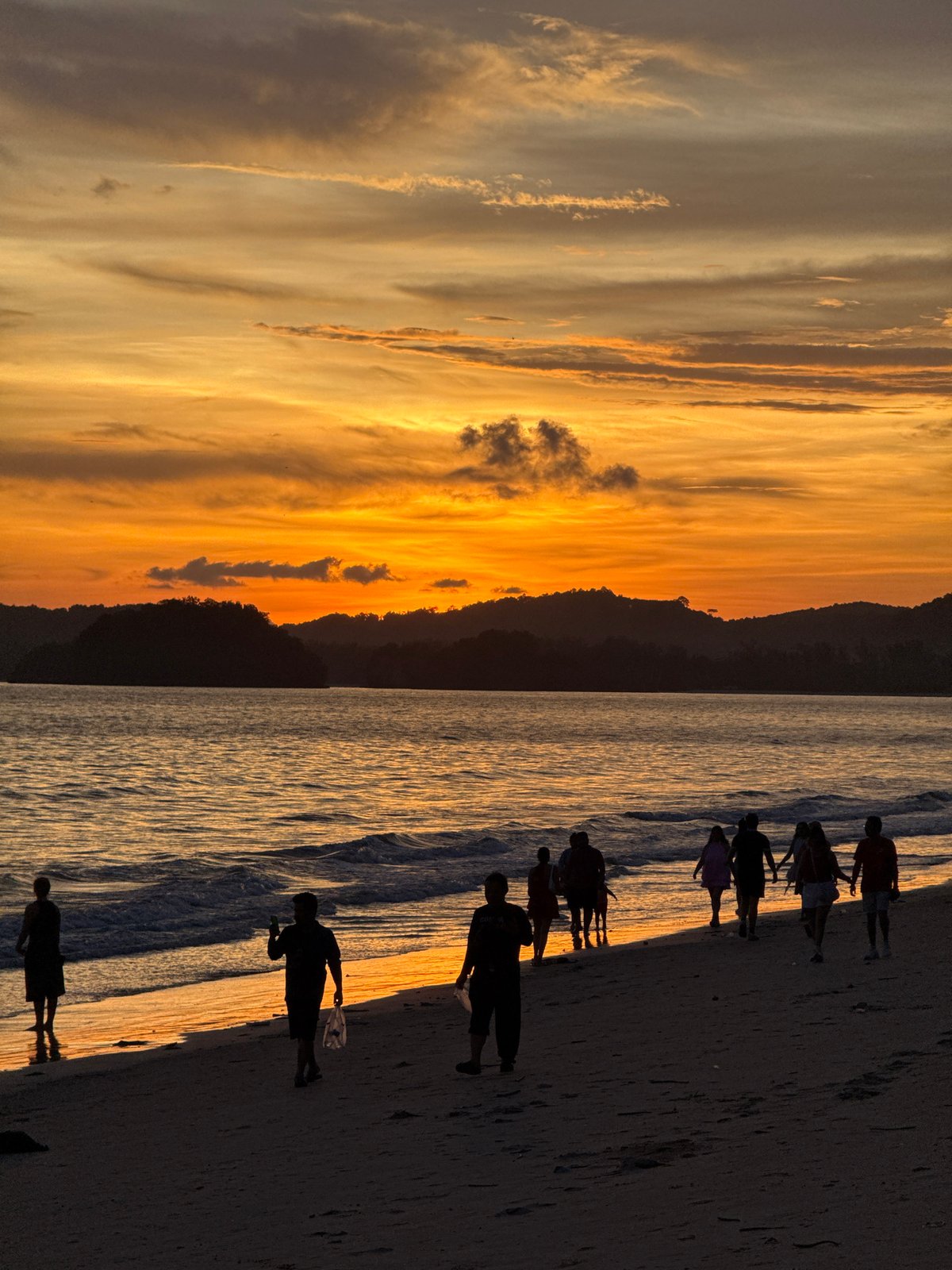 Sunset beach gathering with fireworks in Thailand