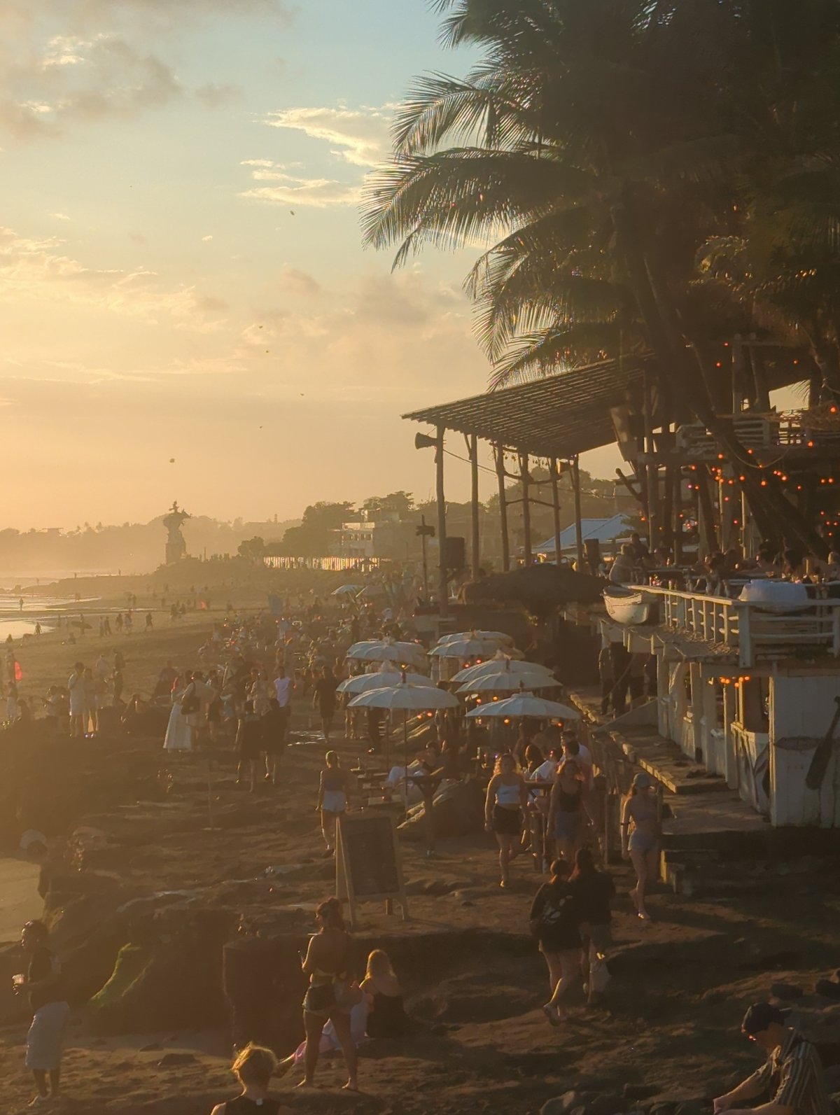 Musician performs acoustic set during crowded North Kuta sunset