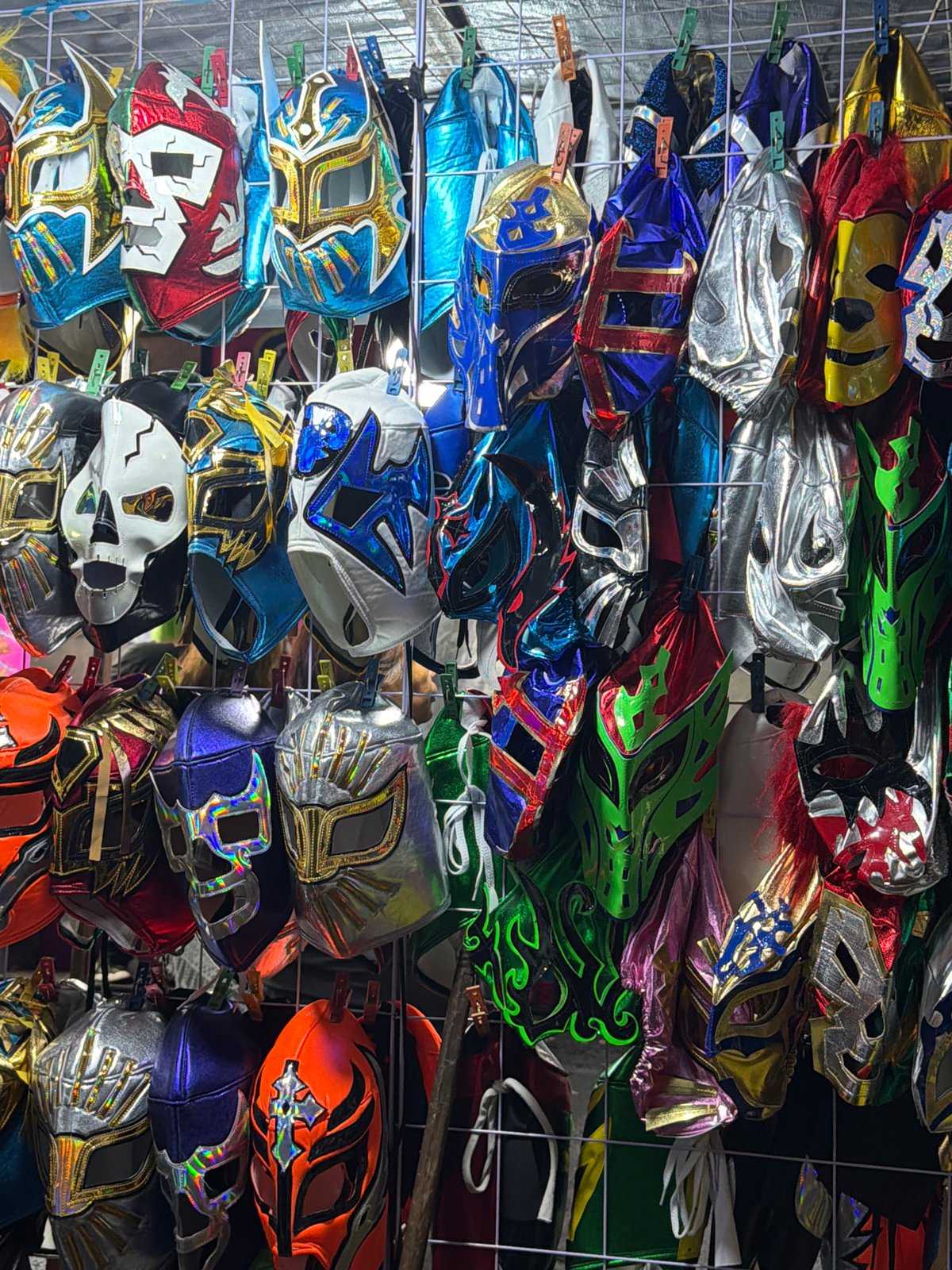Lucha Libre masks displayed on wire rack in Puebla