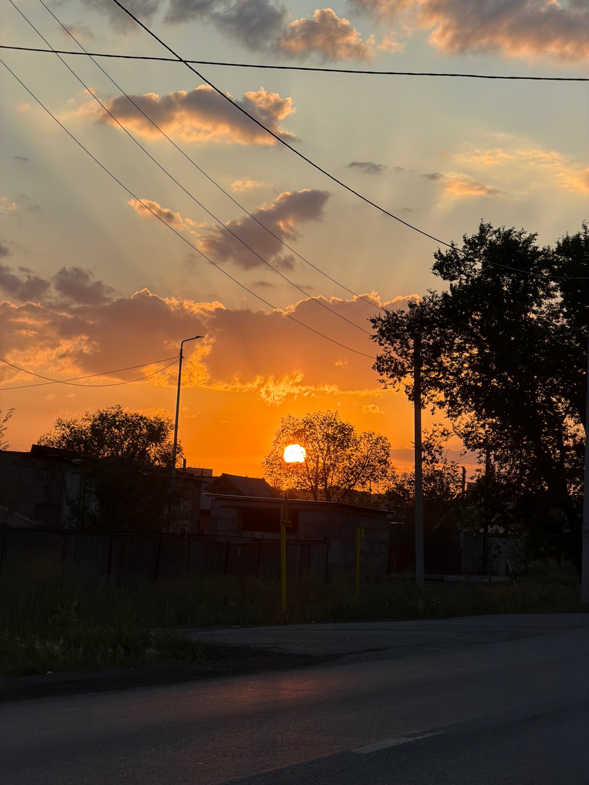Vivid orange sunset silhouettes Temirtau's skyline infrastructure
