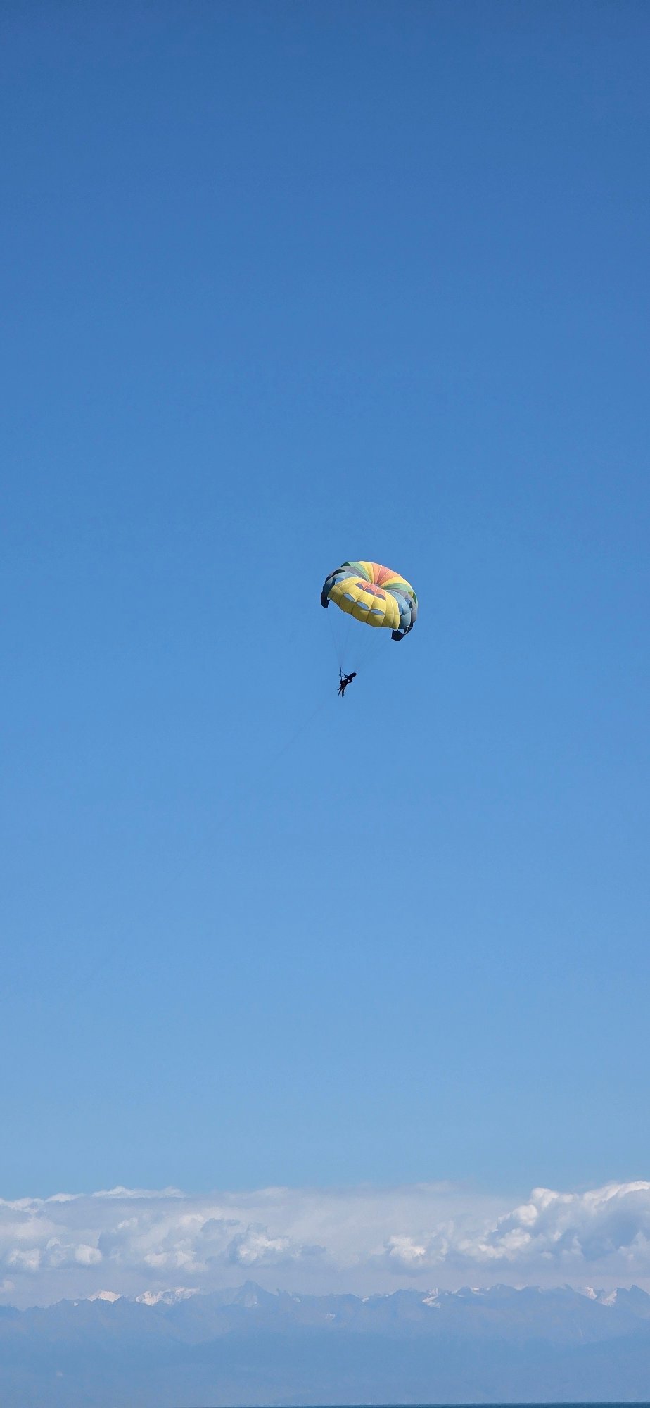 Summer day at a Kyrgyz lakeside beach with parasailing