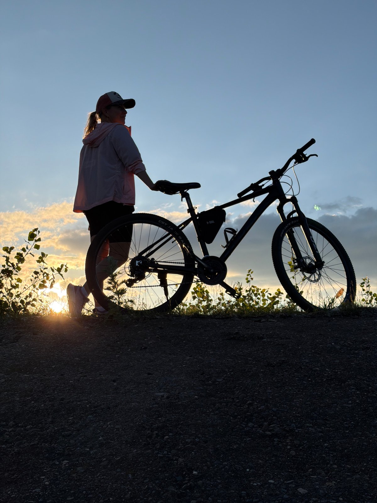 Cyclist pauses for sunset along Kama River in Russia