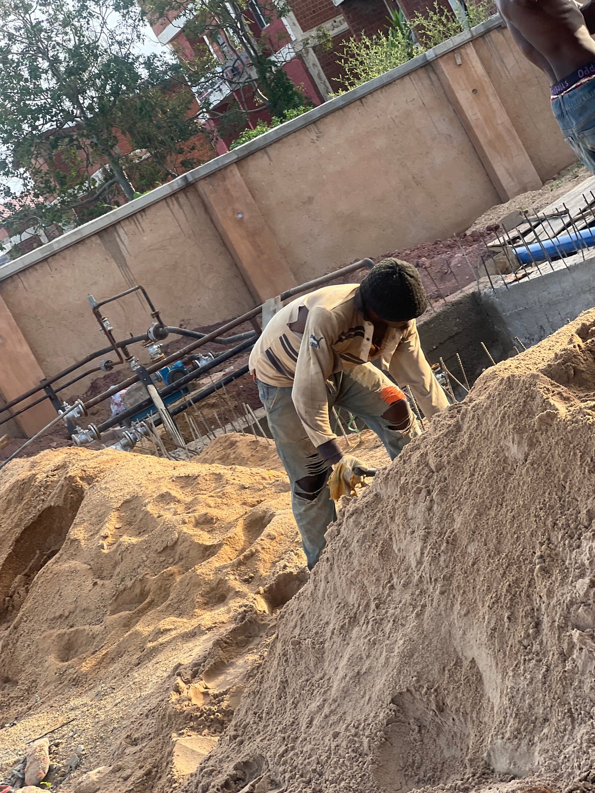 Construction workers conduct manual labor at Nigeria sites