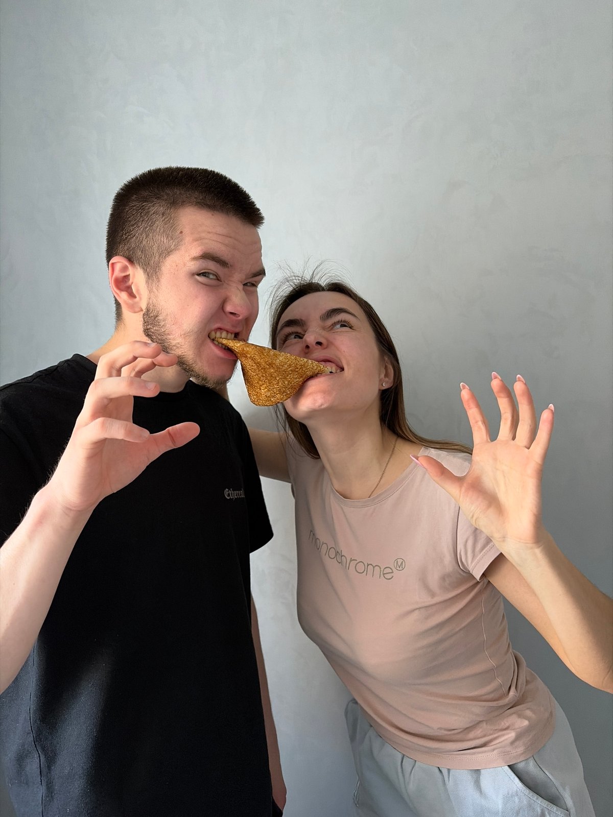 Couple shares food, man poses with fruit indoors