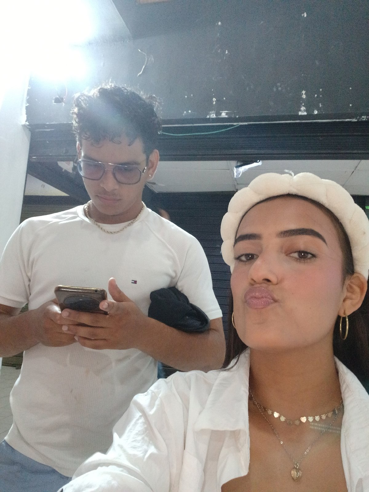 Woman takes multiple selfies in white outfit in Porlamar