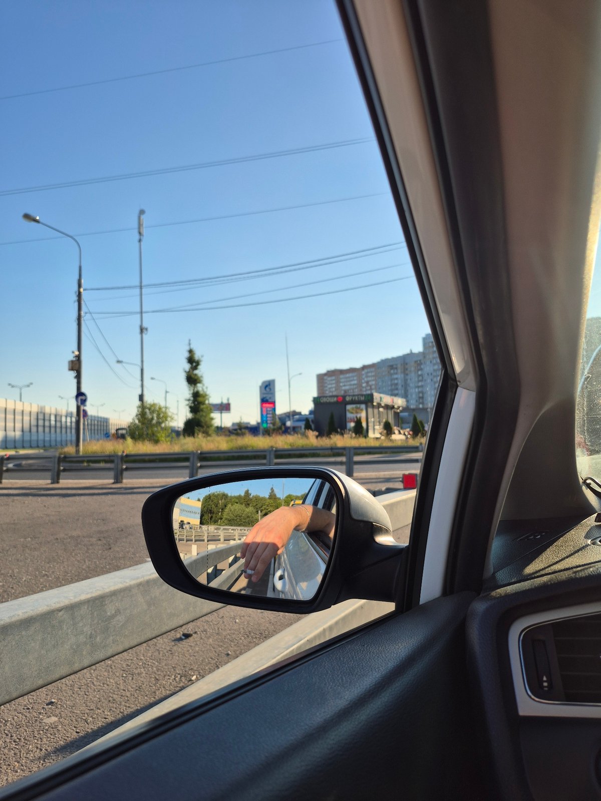 Passenger window views from a moving car on a sunny day.