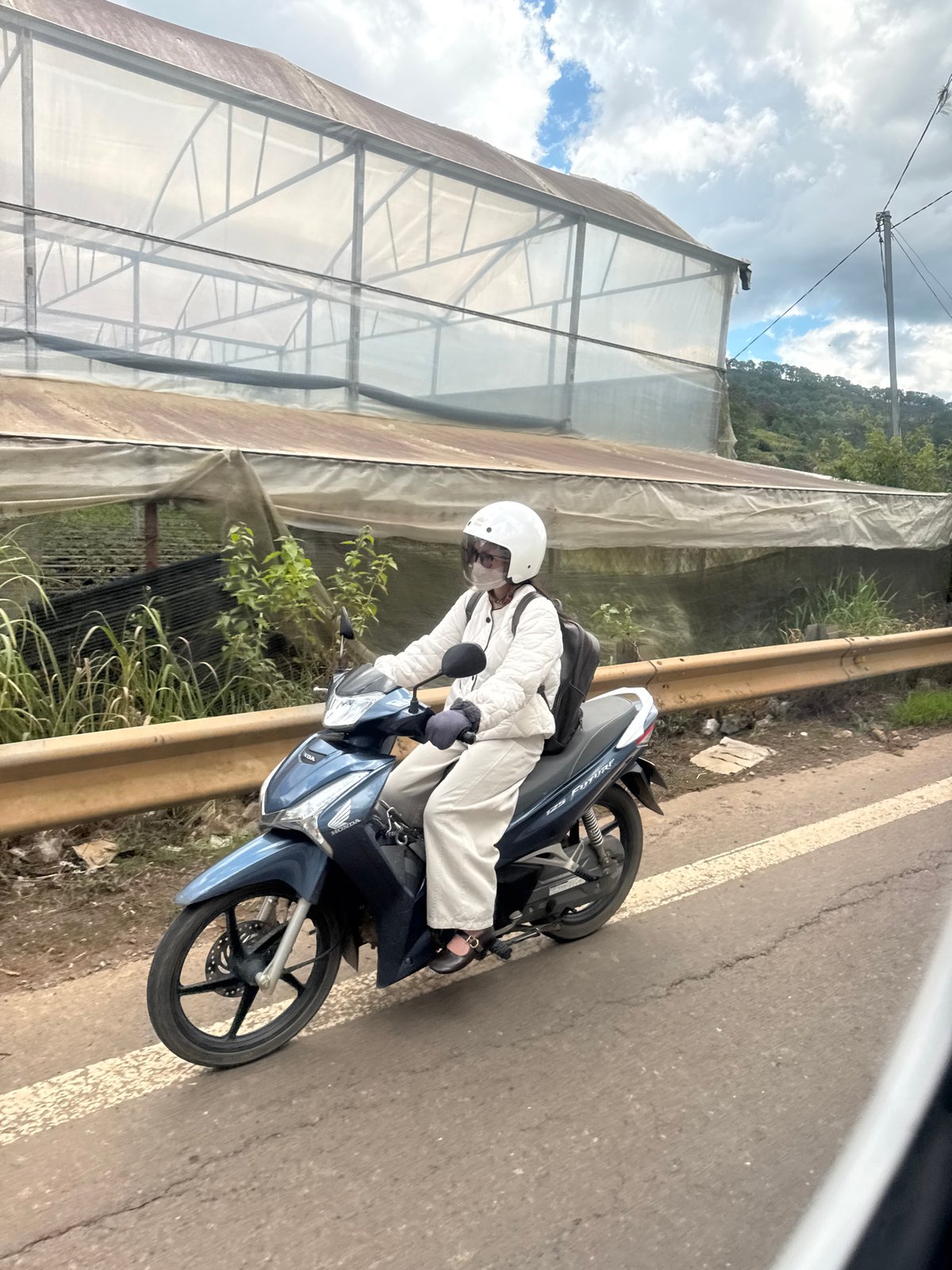 Motorcycle with backpack moves through Đạ Cháy at dawn