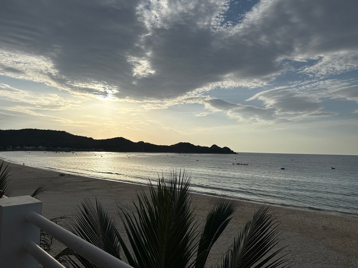 Golden-hour beach scene with dramatic cloud cover and coastal views