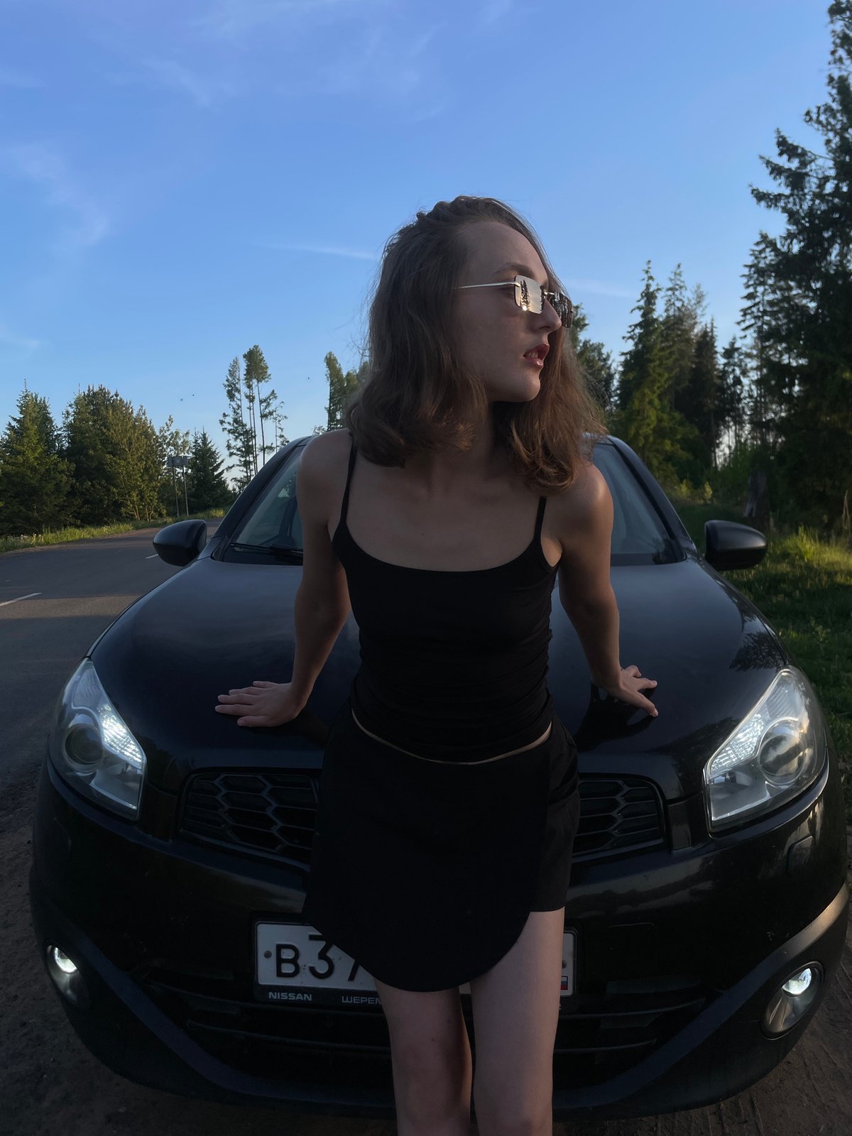Woman poses with Nissan sedan in Russian countryside photoshoot