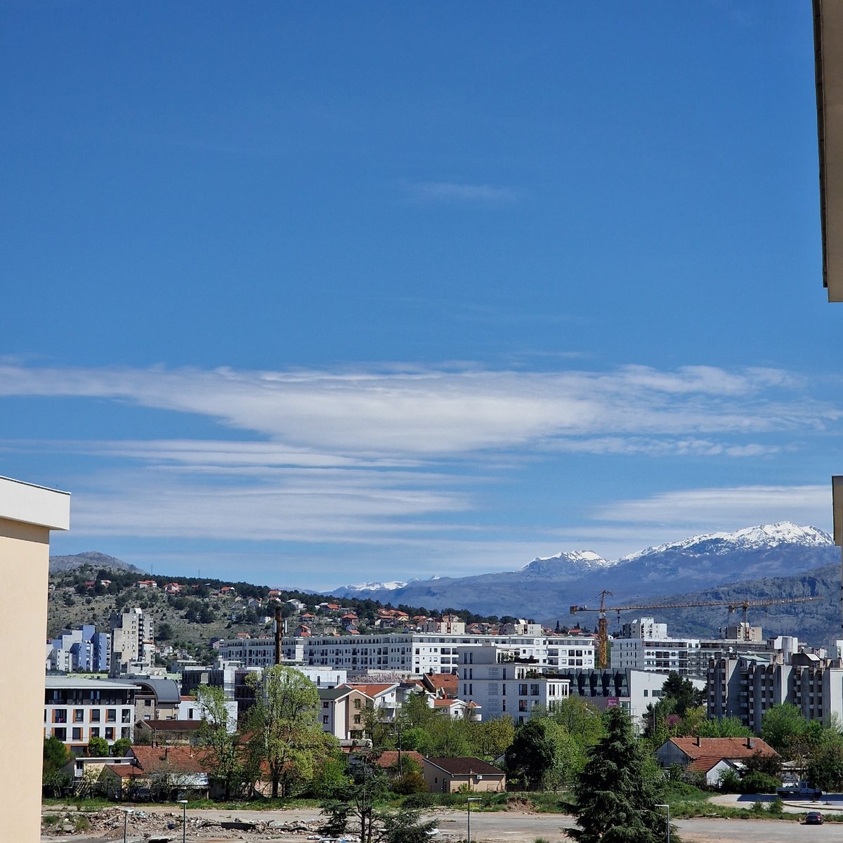 Podgorica cityscape documented against mountainous backdrop with cloudy skies