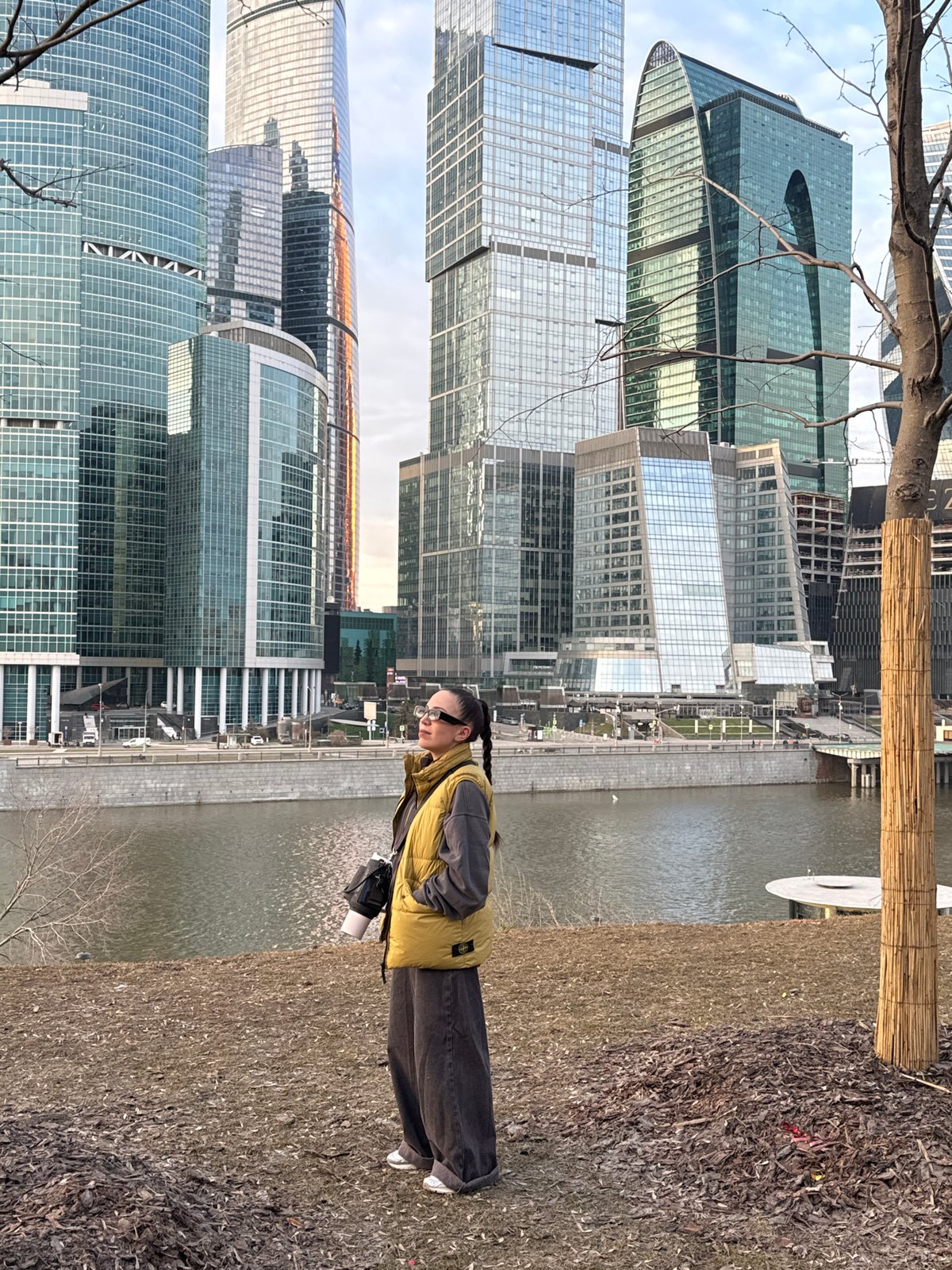 Woman stands by Moskva River viewing Moscow-City skyline