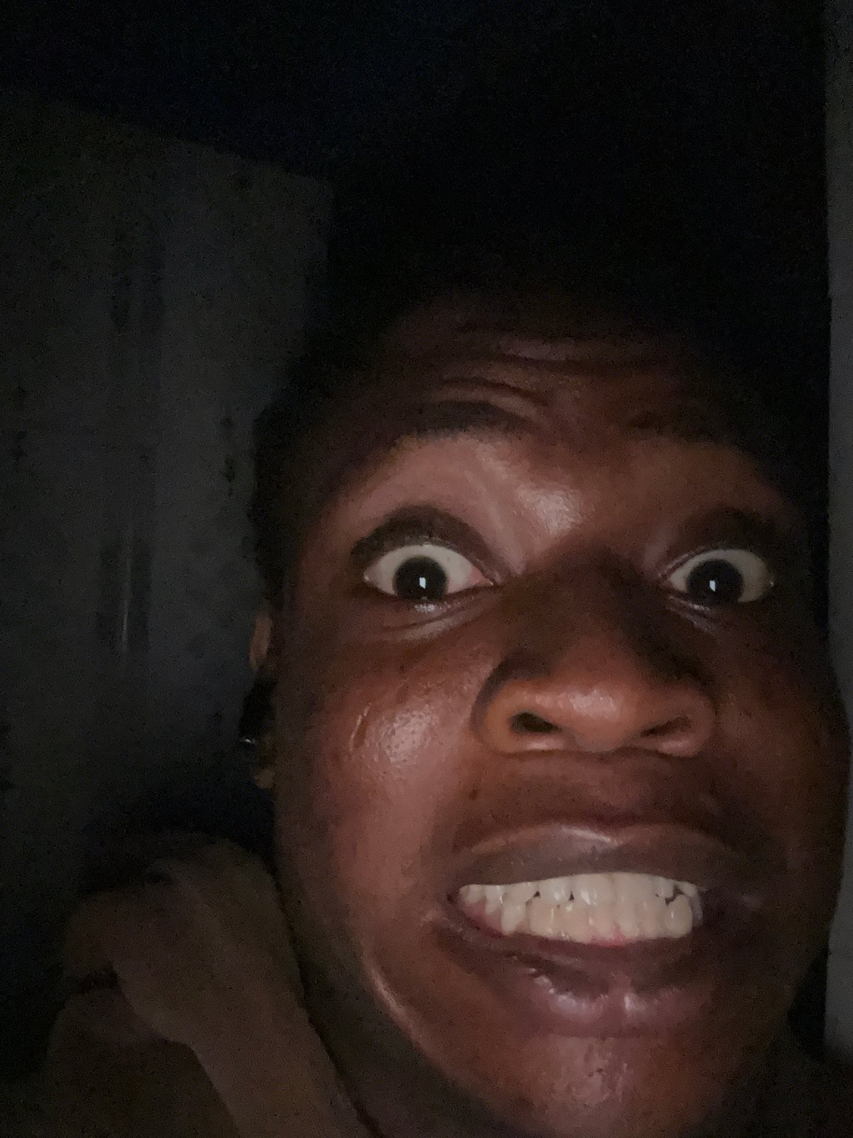 Person photographed making animated expressions during late-night session