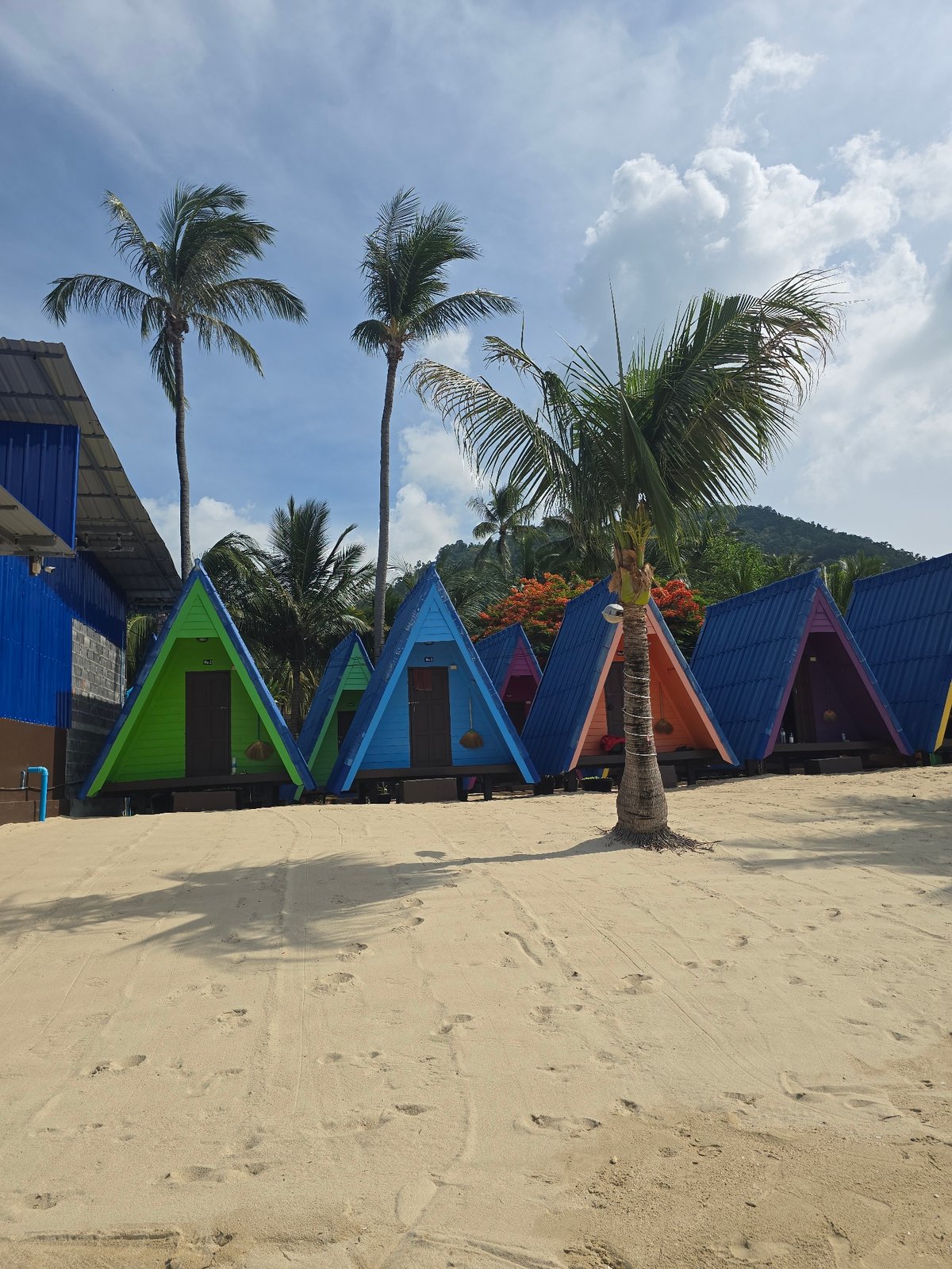 Colorful cabins, a beached boat, and calm water at Baan Lamai