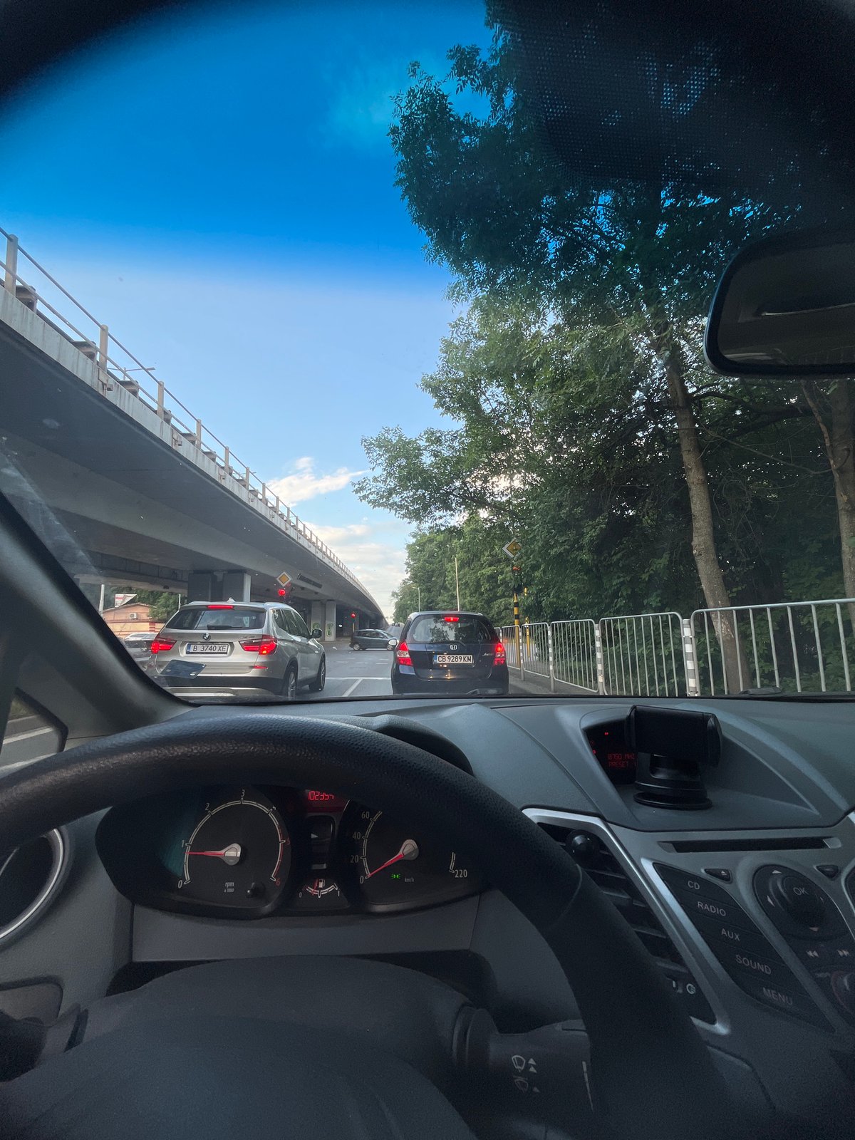 Driver documents sunny day traffic conditions from vehicle