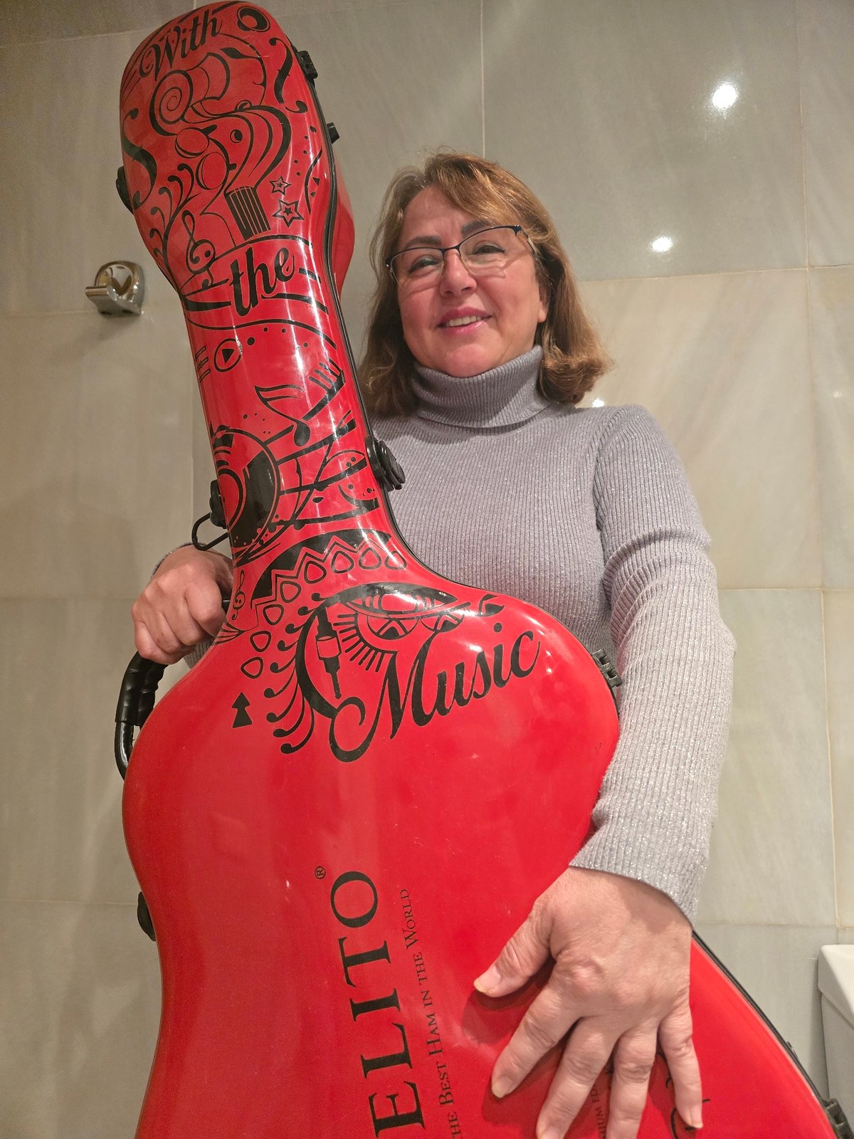 Woman poses with musical instrument case in Barcelona office