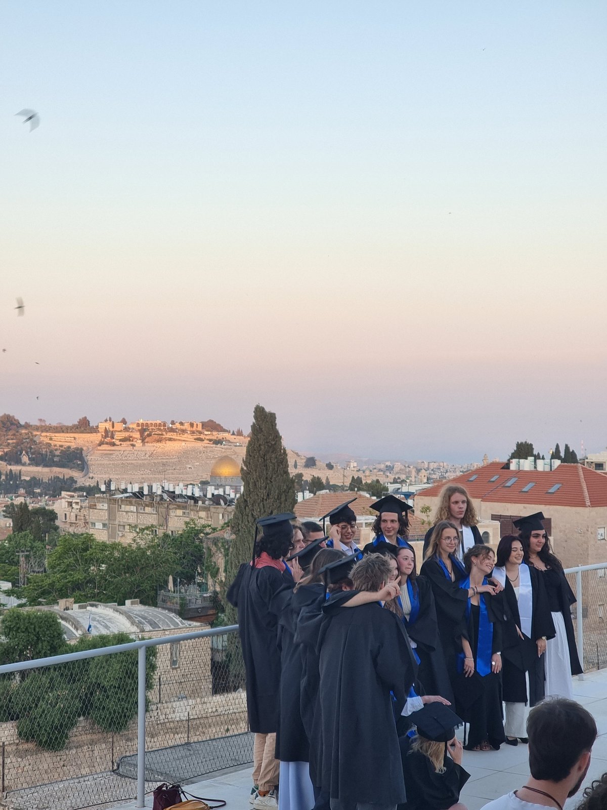 Jerusalem graduation ceremony features iconic skyline backdrop at sunset