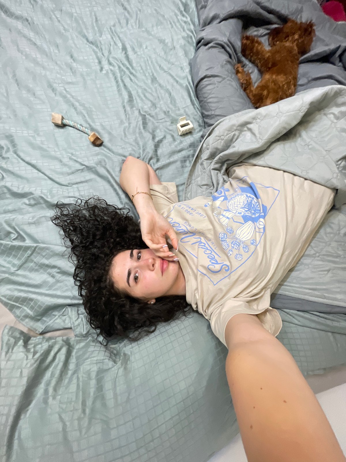 Woman takes playful selfies with poodle in Sofia bedroom