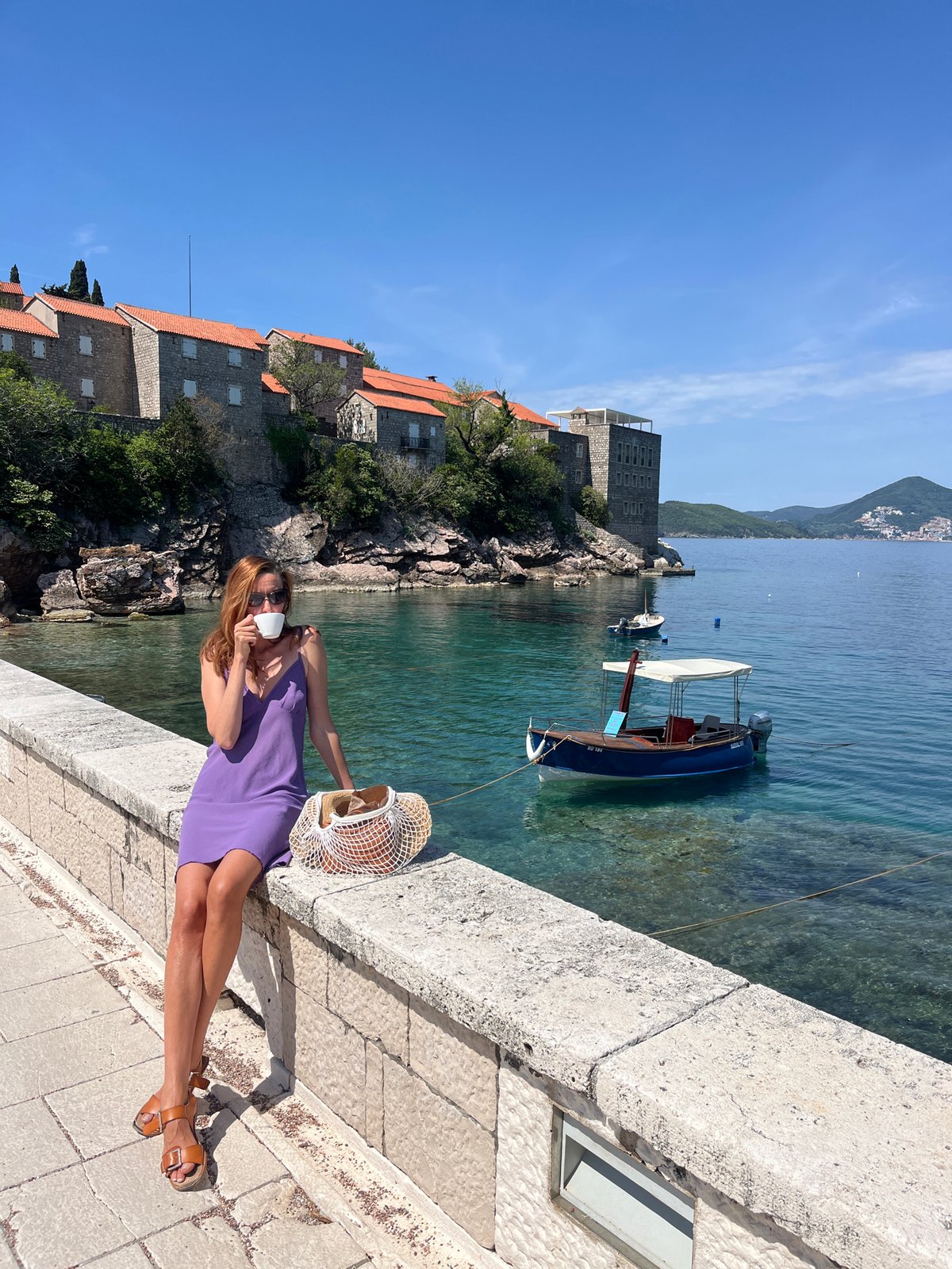 Woman enjoys sunny morning at Sveti Stefan coastal resort