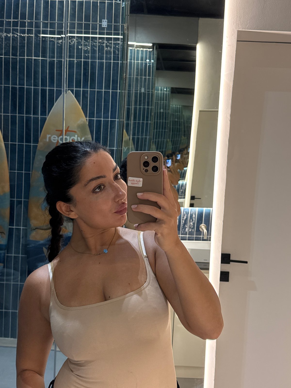 Woman takes bathroom selfie in surf-themed restroom, Kuta Selatan