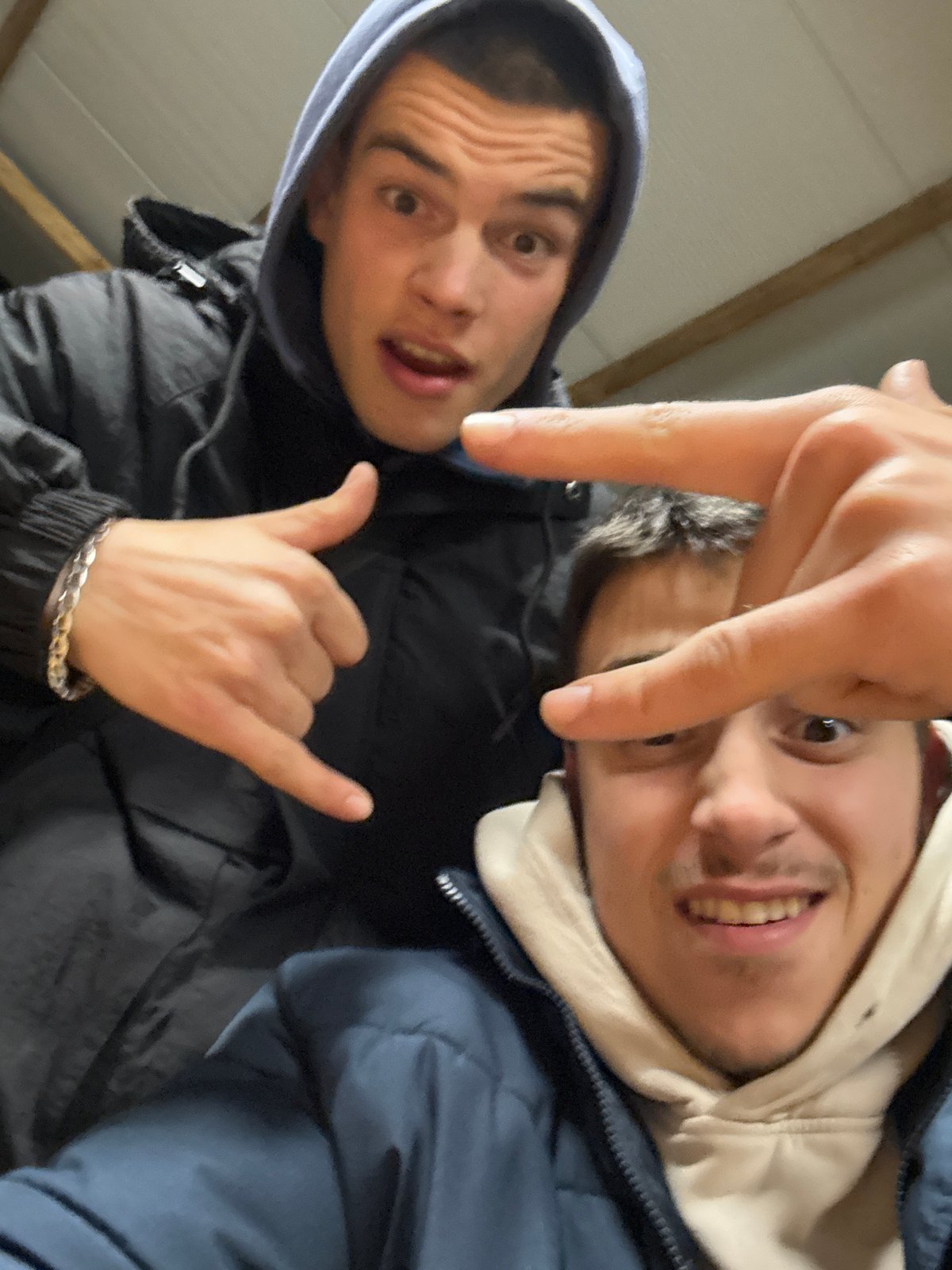 Young men gather outdoors and pose for selfies