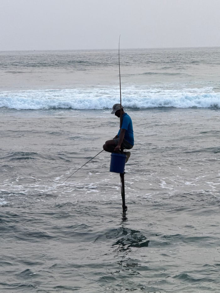 Daily life unfolds along Talpe's coastline with fishermen and beachgoers
