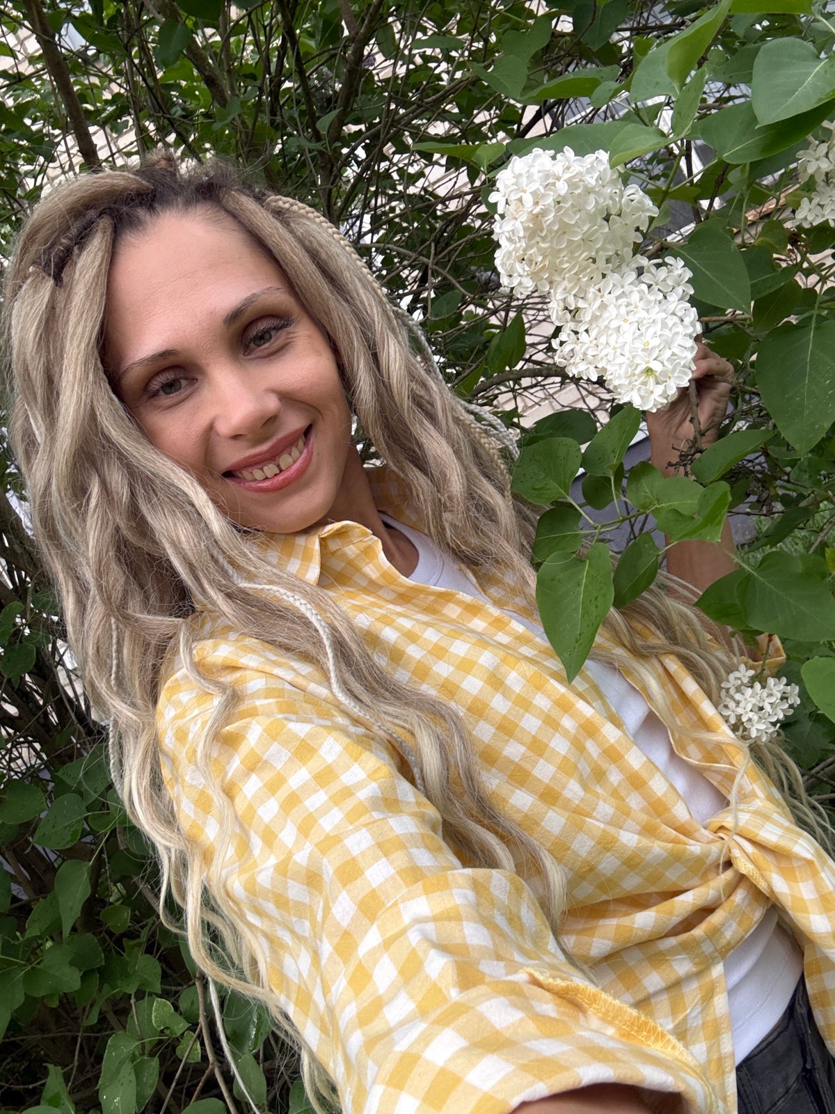 Woman photographed with flowering lilac bush in Zavolzhye, Russia