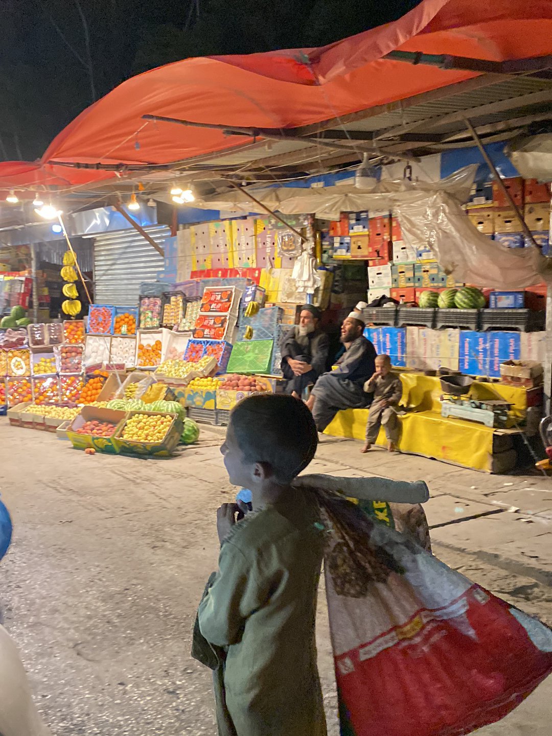 Young boy spotted at nighttime market in Kandahar
