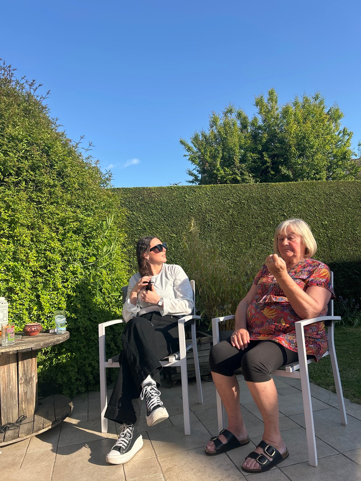 Two women enjoy sunny afternoon on patio in France