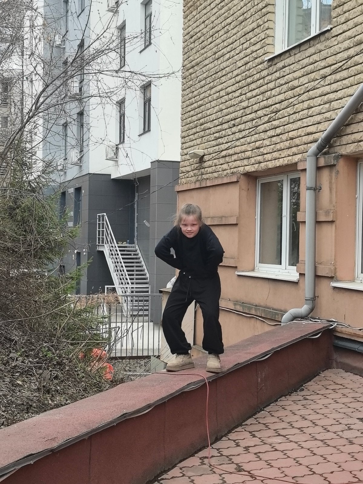 Girl stands on ledge in Nizhny Novgorod urban area