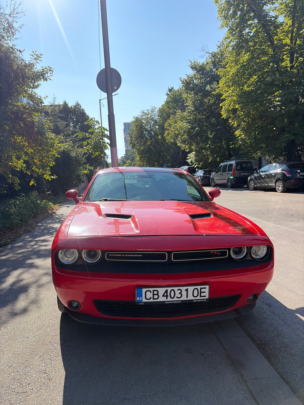 Red Dodge Challenger R/T parked on sunny Sofia street
