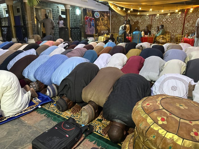 Muslim men gather for communal prayers and evening meal