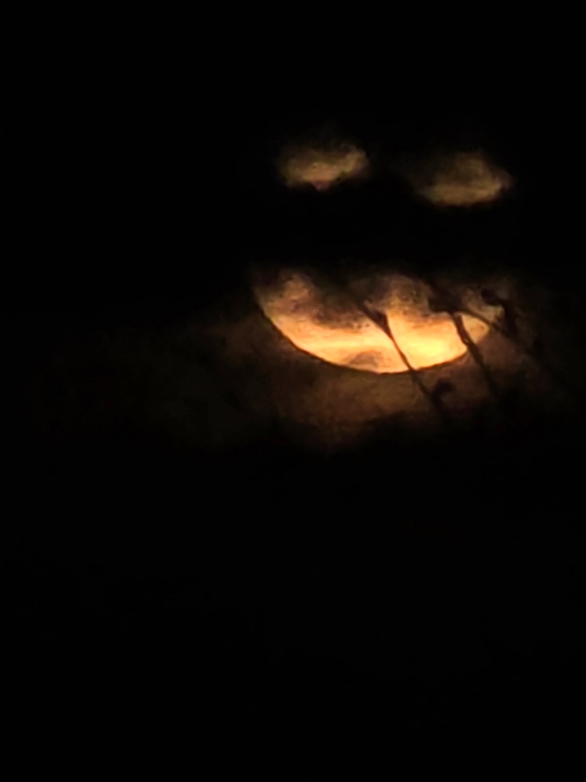 Orange moon observed through clouds over urban area