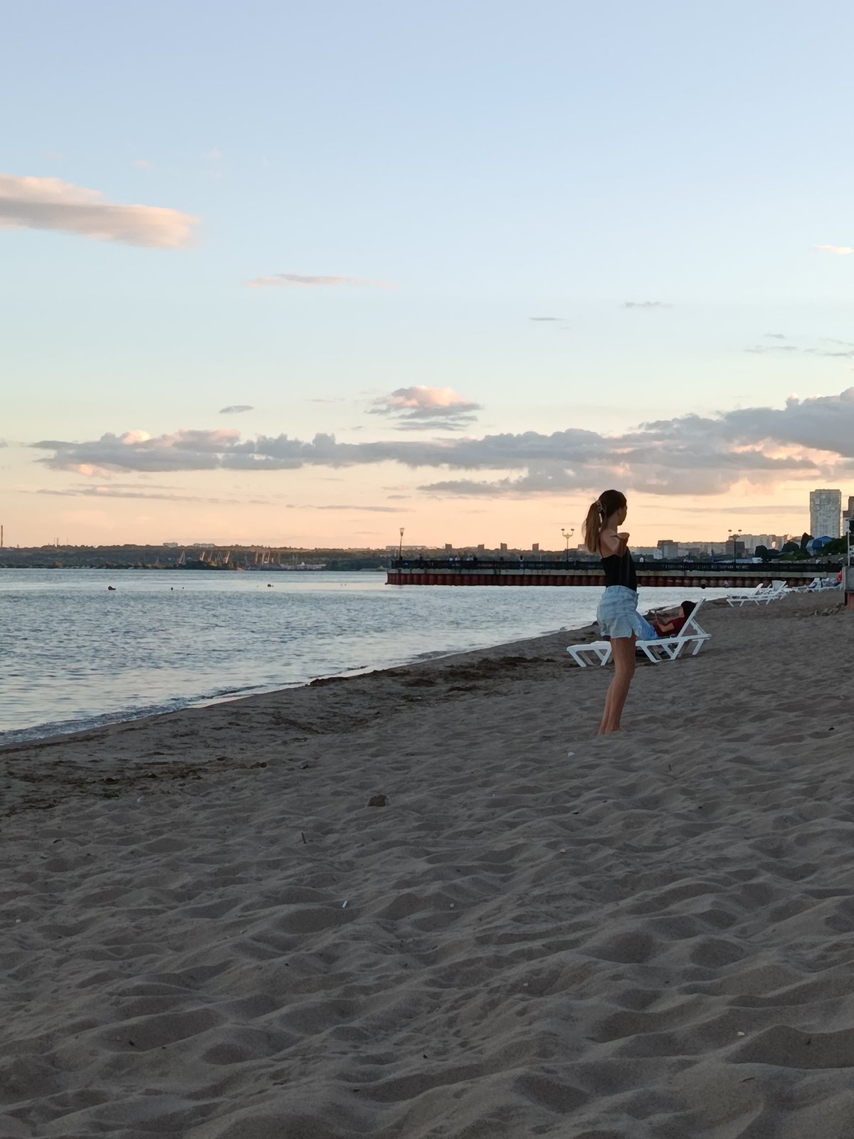Afternoon at the beach with sailboats and a city skyline