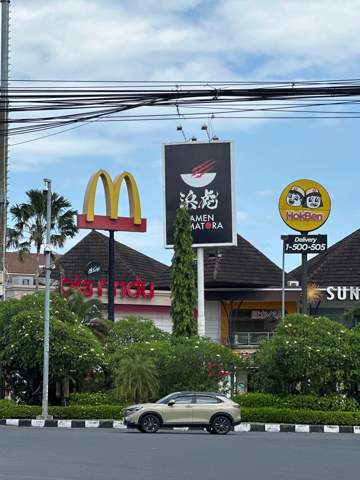 Early morning scooter traffic observed near McDonald's in Denpasar