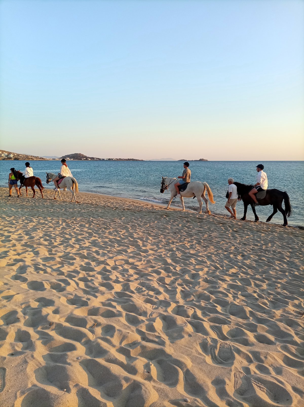 Sunny afternoon at a calm coastal beach, sunset included.