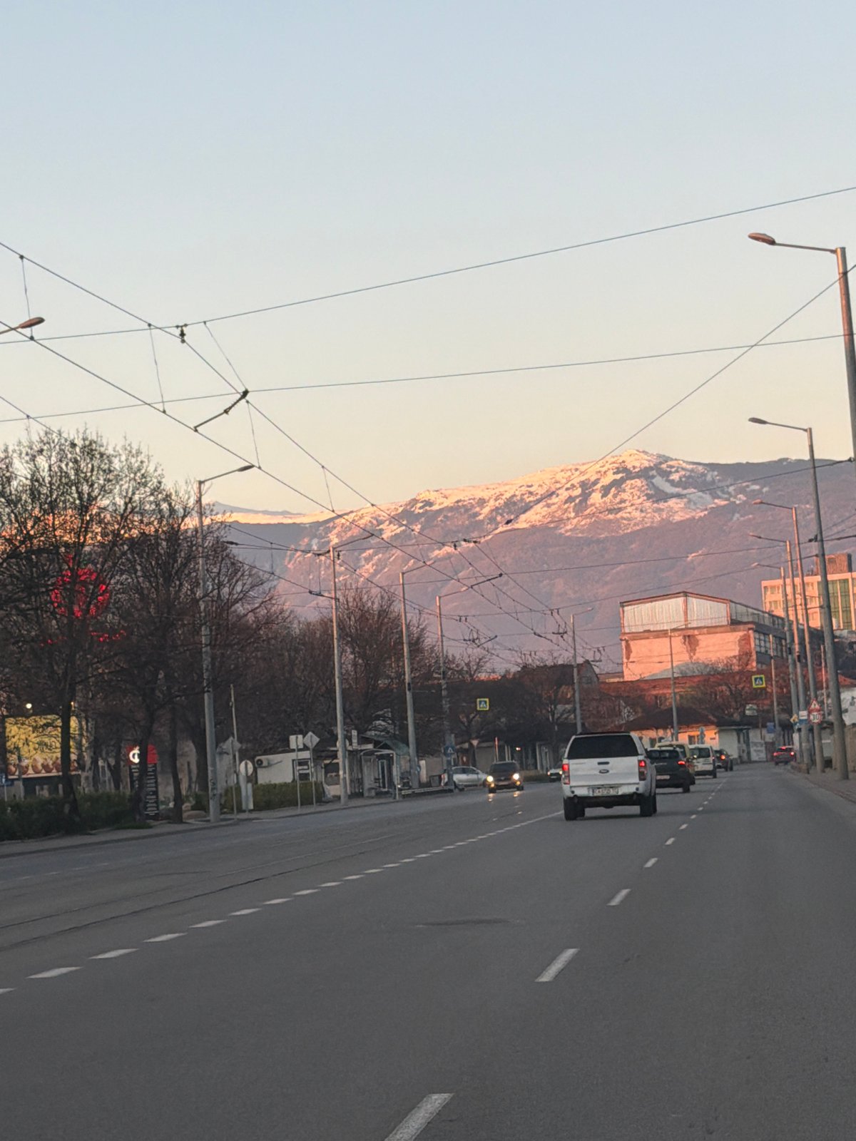 Morning street scene documented in Sofia with mountain backdrop