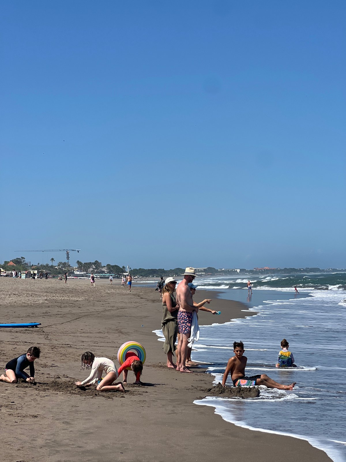 North Kuta beach buzzing with surfers and beachgoers on a clear morning