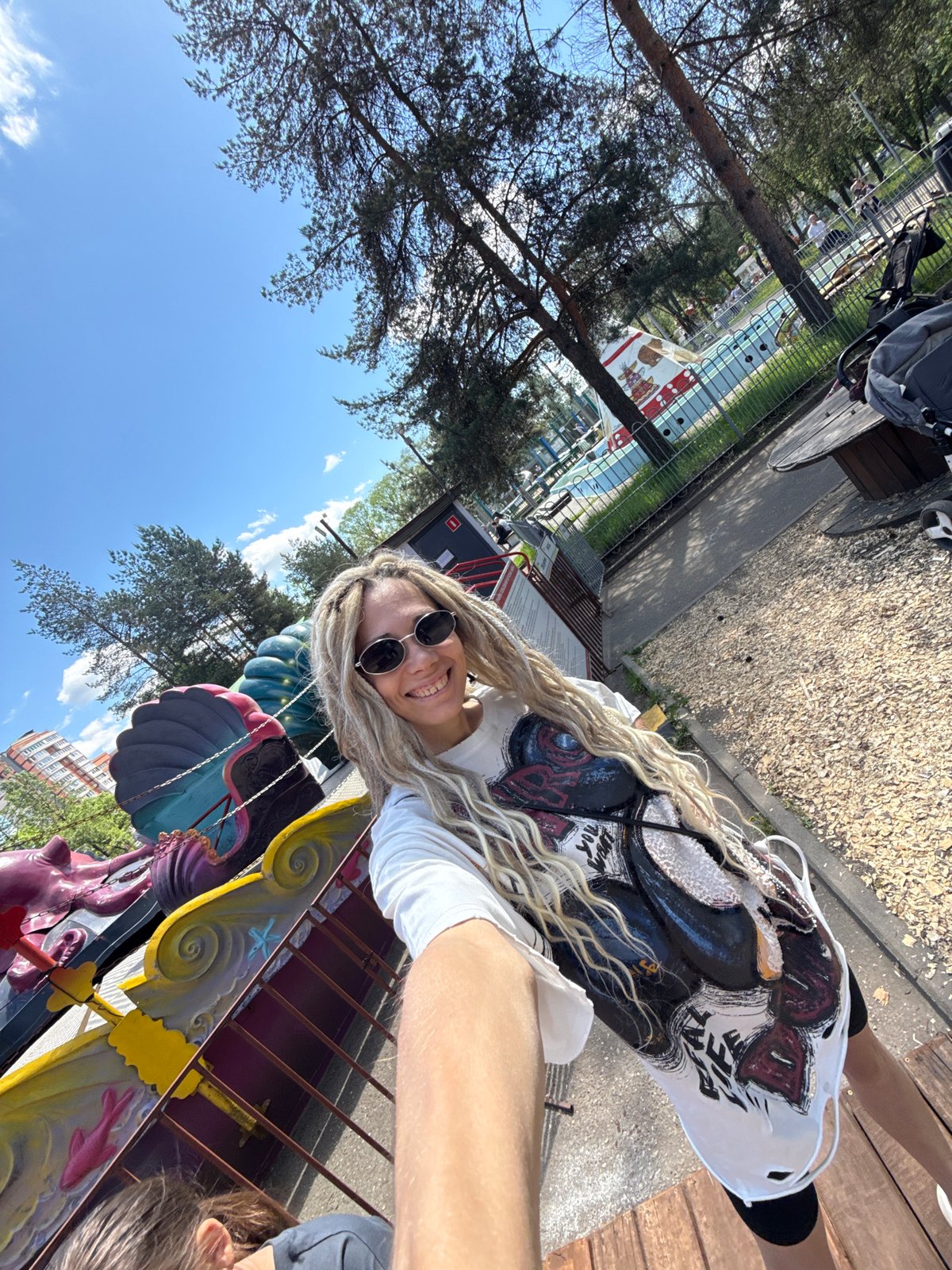 Woman rides colorful carousel at urban amusement park