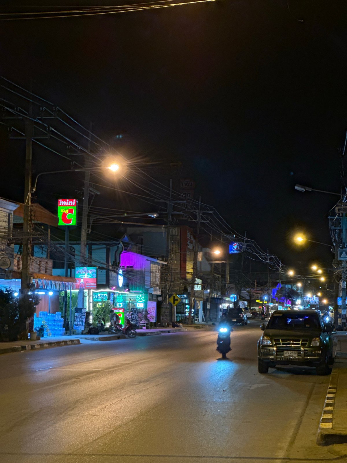 Baan Mae Nam's neon-lit commercial strip, shops and night market