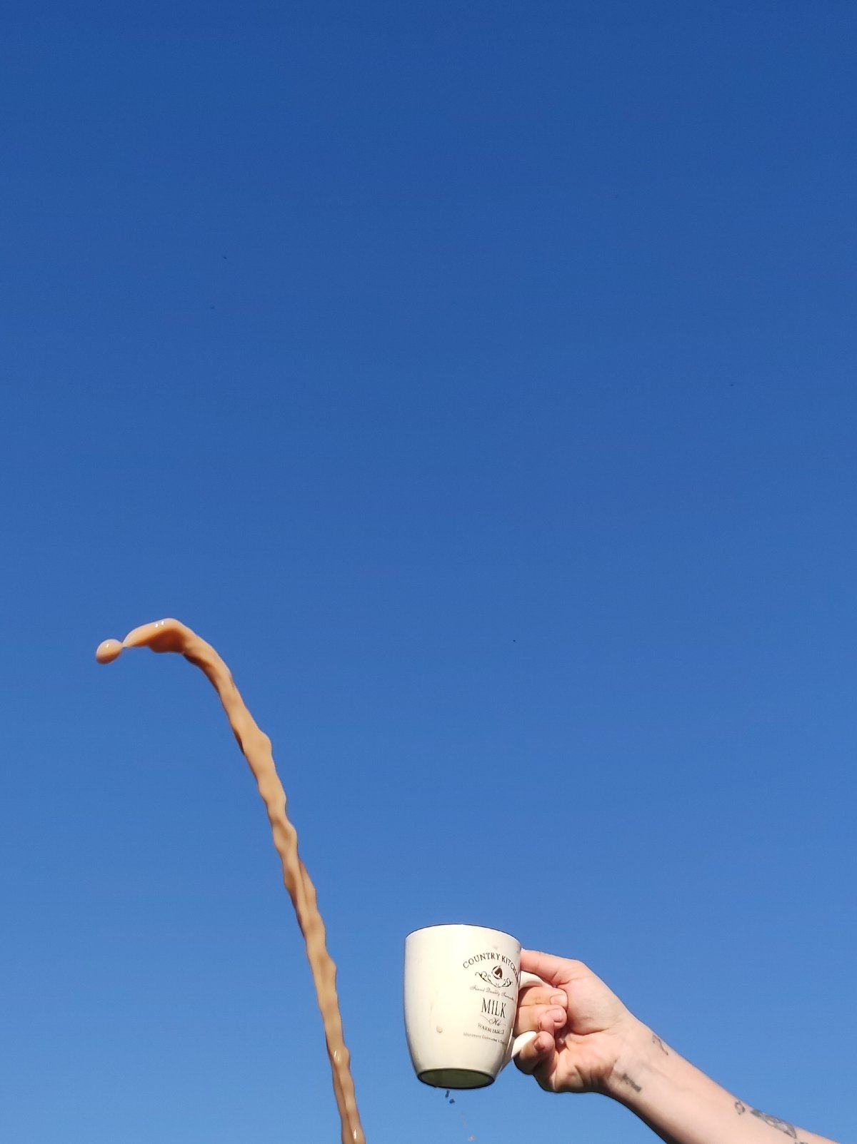 Woman spills liquid from mug under clear sky in Russia