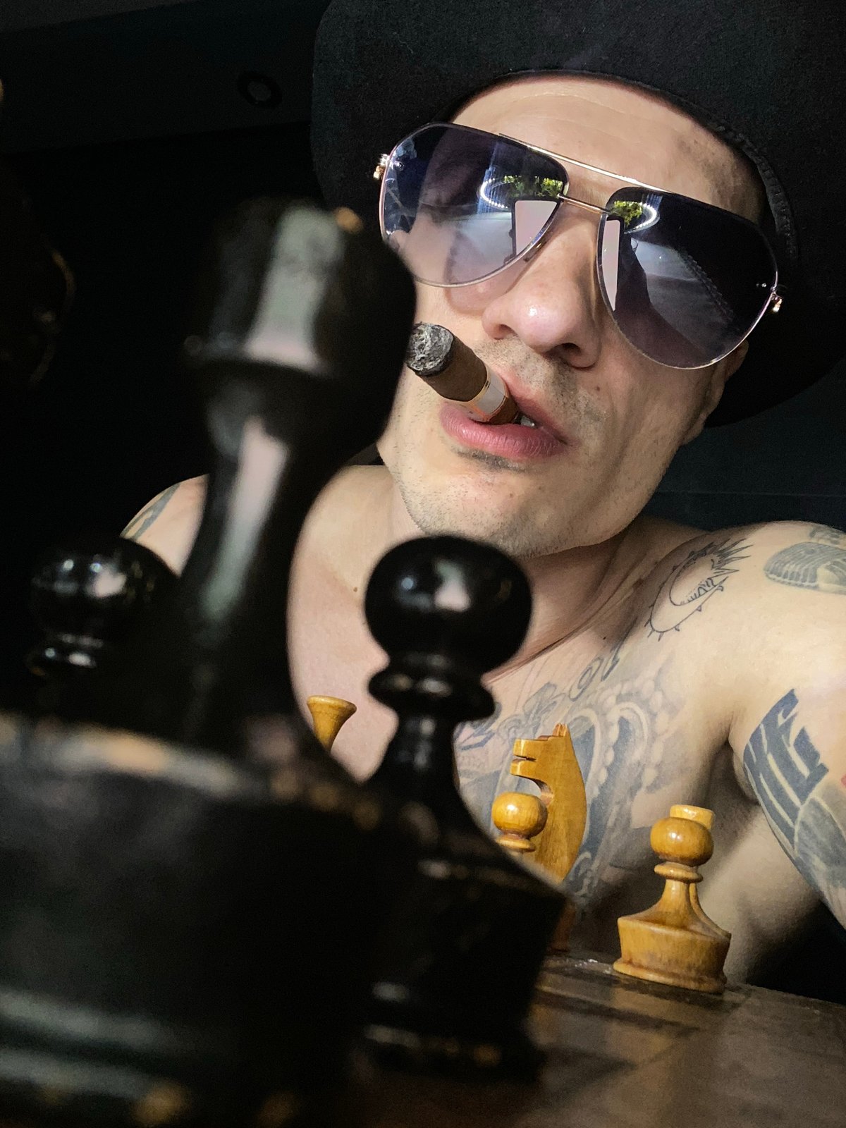 Tattooed man with fedora spotted smoking cigar in Pleven