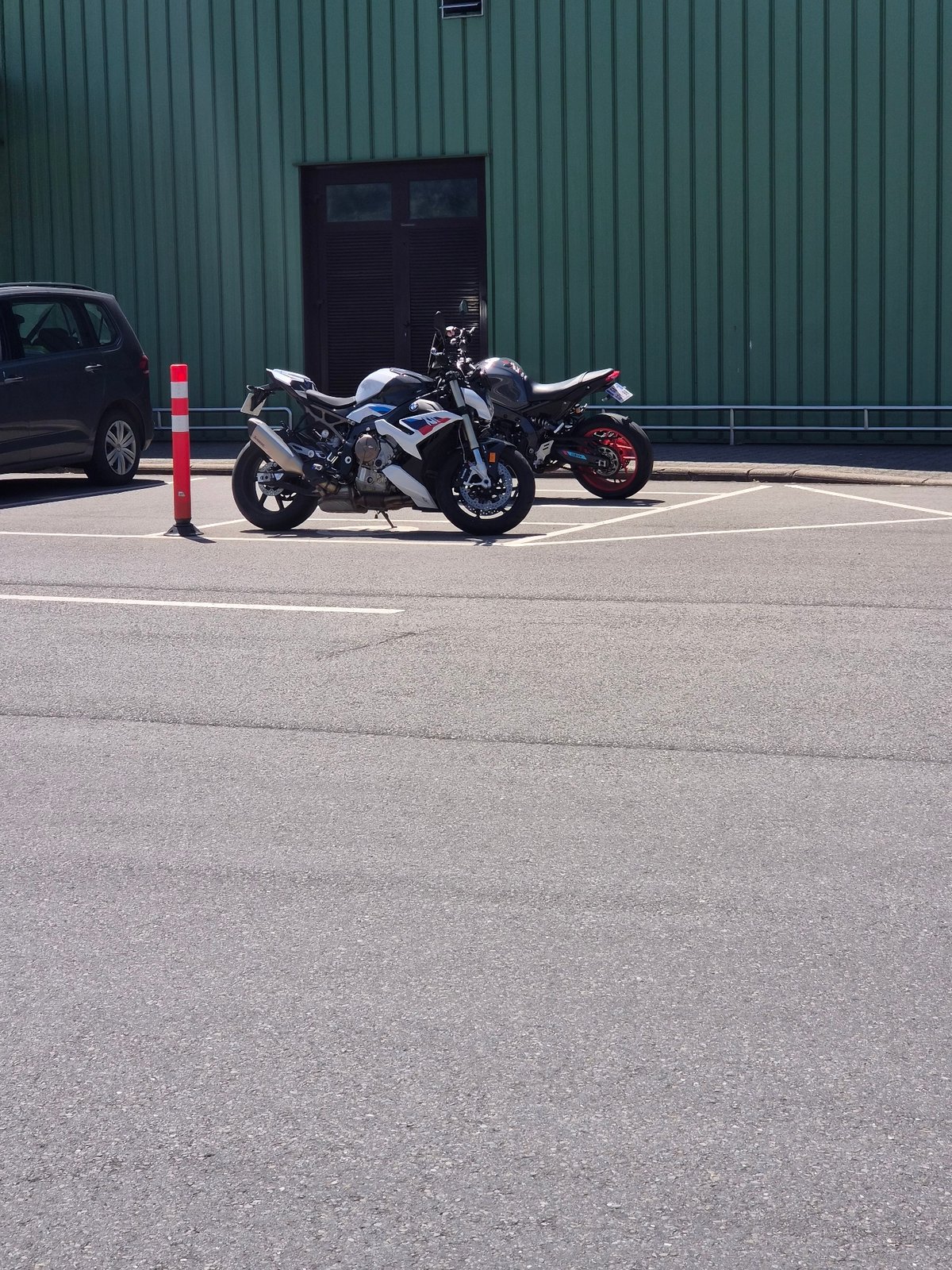 Motorcycles parked in a sunny Leudelange lot