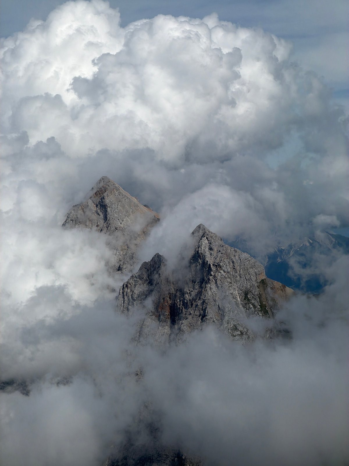 Rocky Alpine peaks disappear into sunlit clouds above Garmisch-Partenkirchen