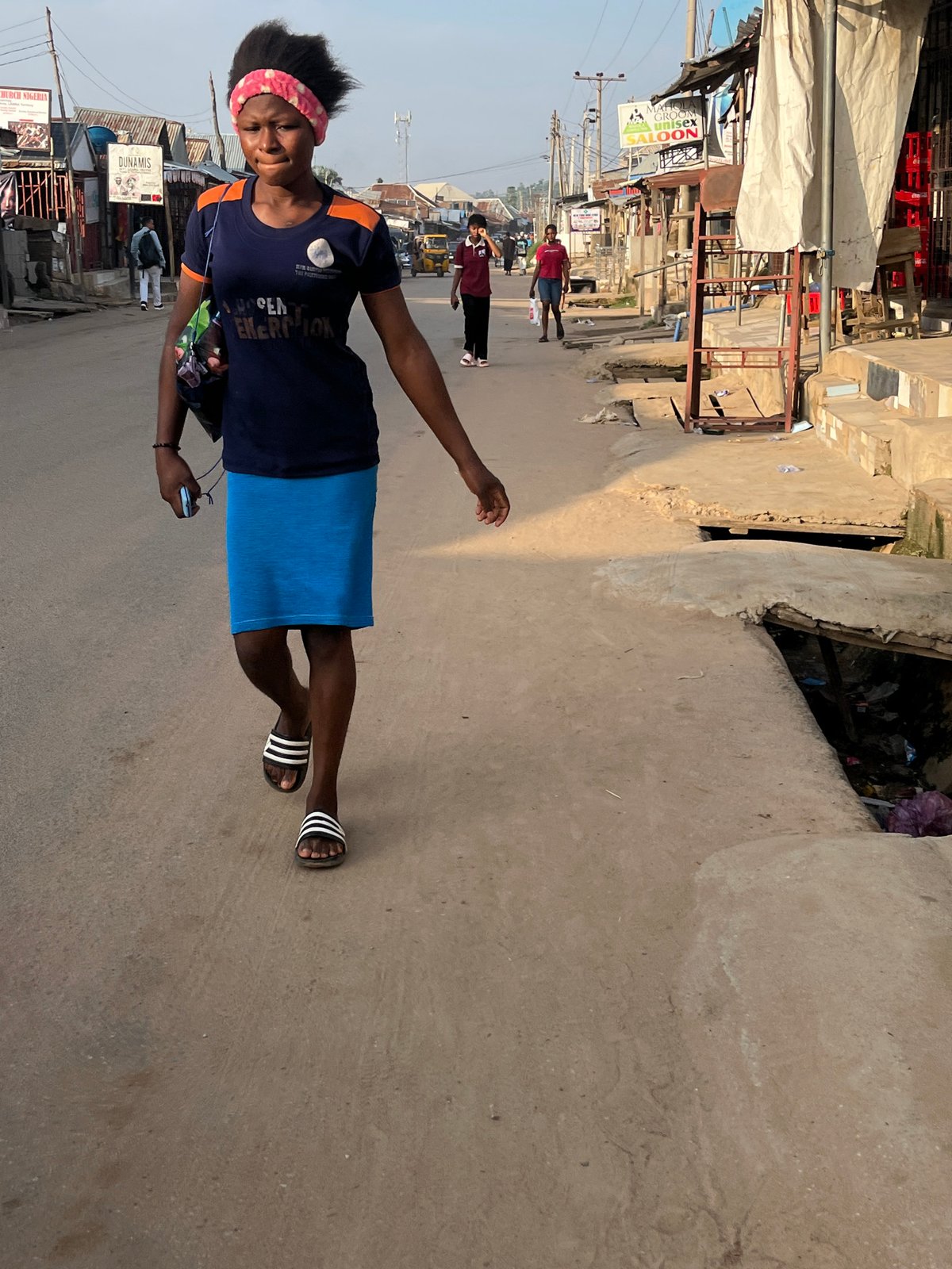 Morning foot and motorcycle traffic on Abuja neighborhood streets