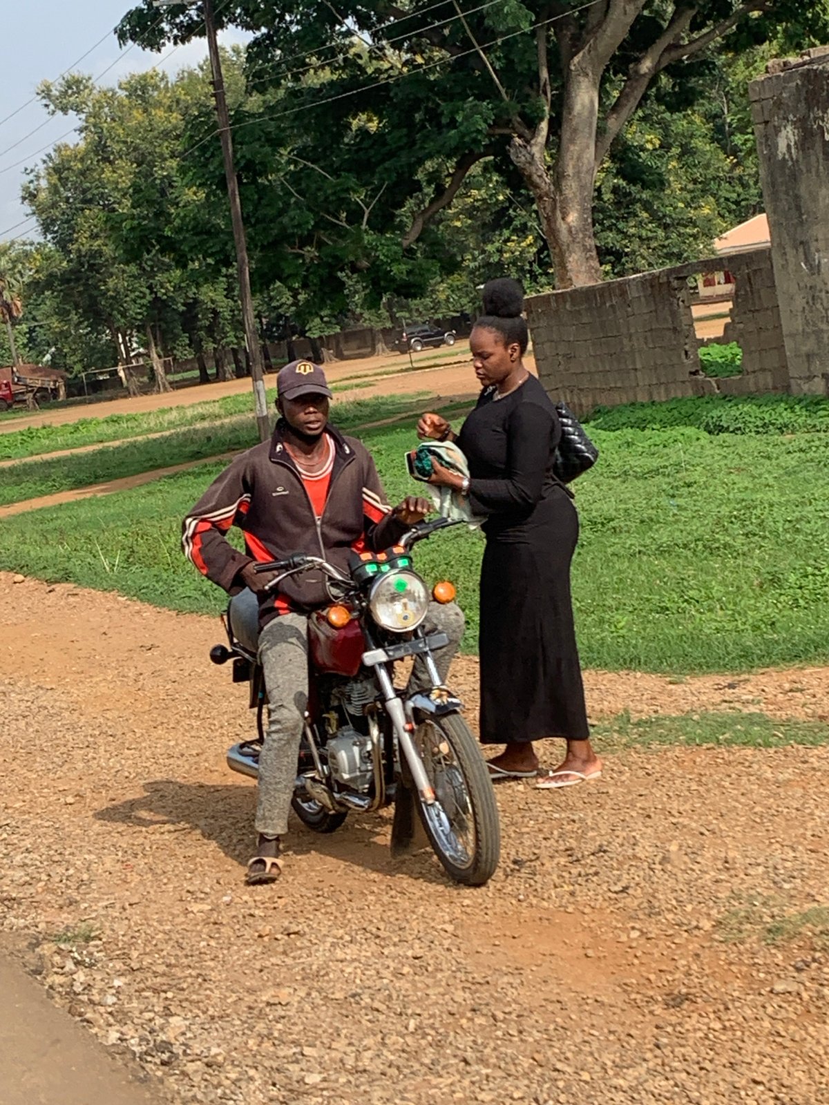 Morning gathering observed in Agban, Nigeria involving motorcycle and pedestrians