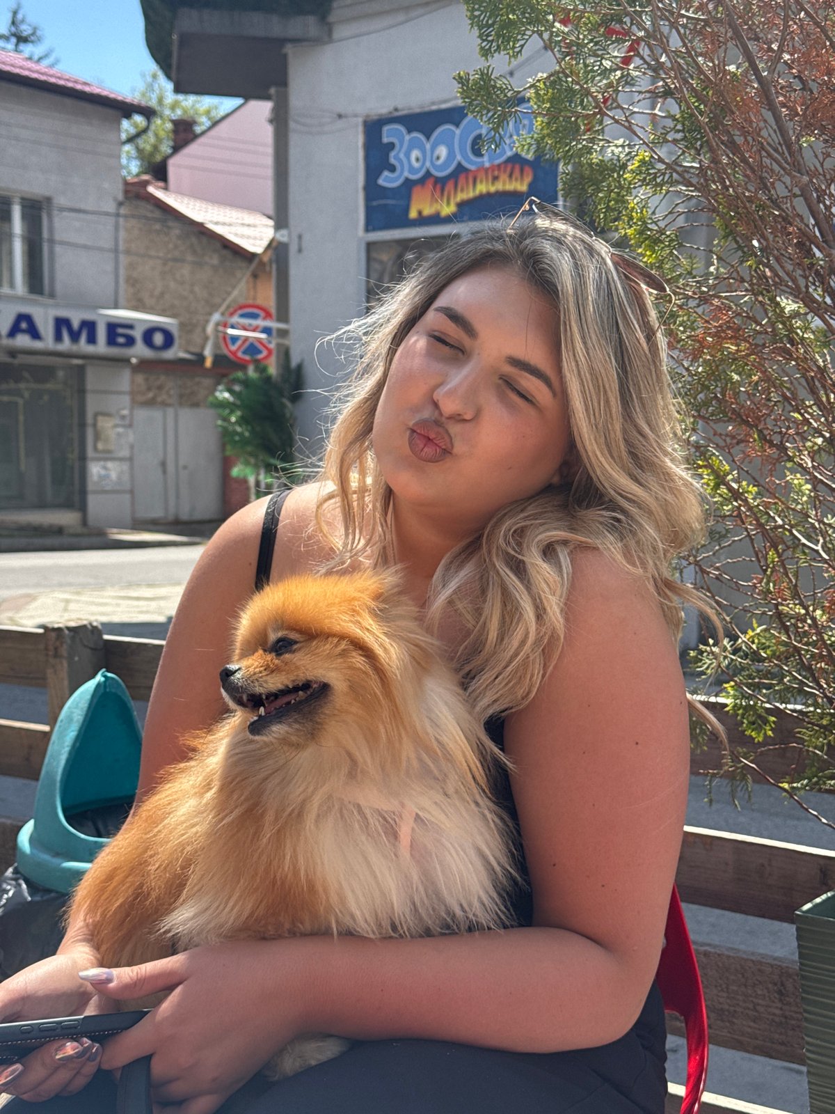 Woman poses with Pomeranian dog in sunny Dupnitsa